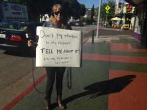 KPCC reporter Meghan McCarty canvasses the streets of Los Angeles with a sandwich board and a microphone. (KPCC photo)